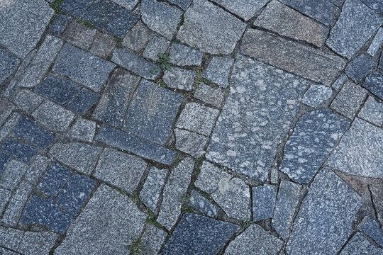 Texture of grey granite stone paving slabs and cobblestones