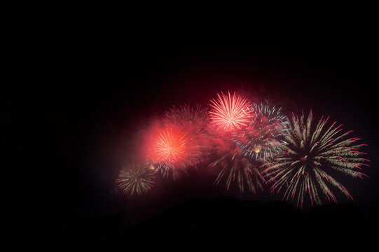 View of vibrant red and white fireworks illuminating the night sky during the Independence Day celebrations in Lahore, Punjab, Pakistan.