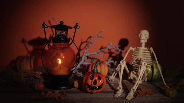 Slow push in on candle lantern, pumpkin and skeleton scene for Halloween party decor, spooky backdrops and autumn design