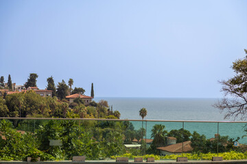 Fototapeta premium Scenic view of Kaleici old town from a modern glass railing observation deck in Antalya, Turkey. Mediterranean coastal resort cityscape, blue sea, and travel atmosphere.