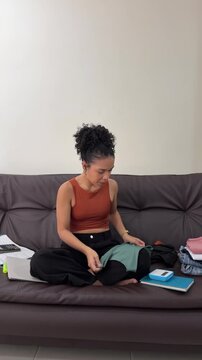 Young woman small business owner folding clothes