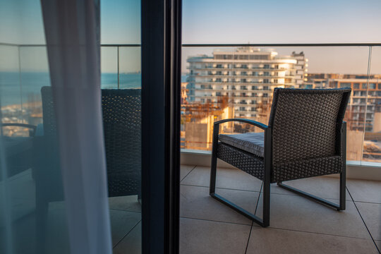 Black chair on the apartment balcony with view on sea.