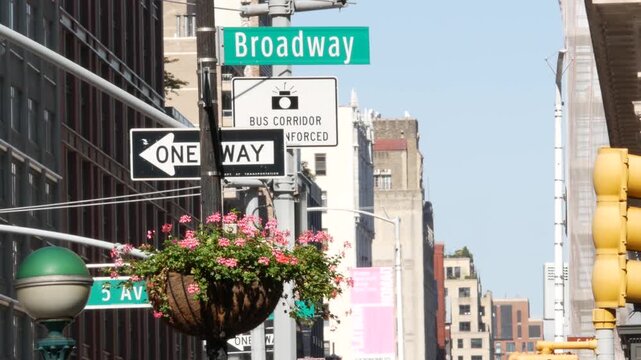 New York City Broadway street sign in Manhattan Midtown, United States. Urban road sign, traffic sign. Building architecture in Flatiron district. Crossroad with 5 fifth avenue. Subway metro globe.