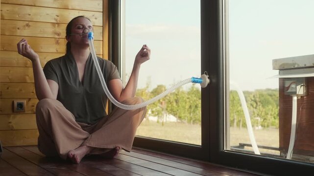 Middle-aged woman meditates in lotus pose on the floor of an apitherapy chamber, focusing on breathing during a calm beehive air wellness session.