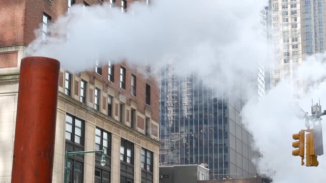 New York City Midtown urban tall building architecture, Manhattan street, 8 avenue, United States of America. Skyscraper towers near Columbus Circle, USA. Hot steam smoke vapor. Orange stack tube pipe