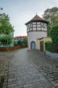 20 August 2026, A historic half-timbered tower stands along a cobblestone street in Iphofen, Bavaria, Germany.