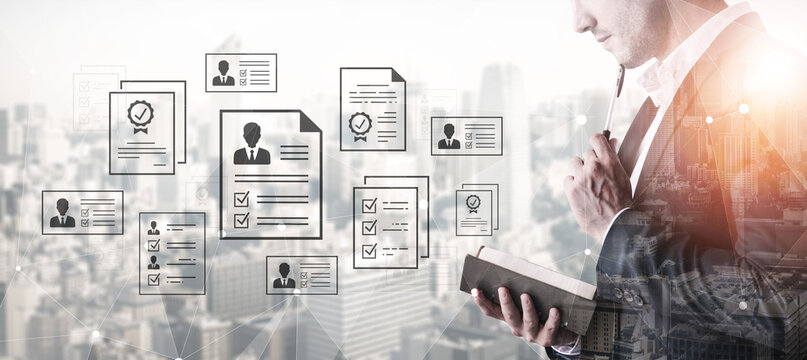 Business professional reviewing application documents and resumes with digital overlays of city skyline and workflow elements in a modern office environment. Entropy.
