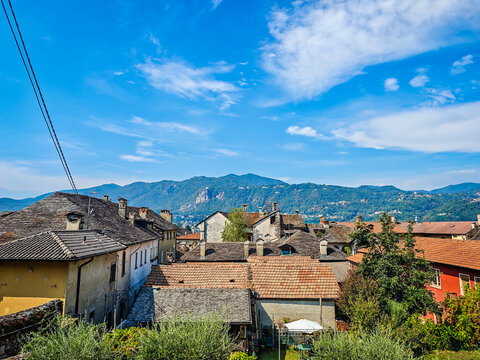 Panoramic view of Orta San Giulio on the shores of Lake Orta, Piedmont, Italy. Aerial drone view showcasing the historic lakeside town and picturesque Alpine landscape