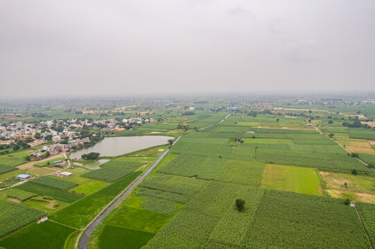 Aerial view of Dwarka Expressway landscape near Gurugram, Haryana with green fields and pond.