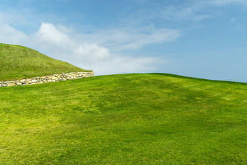 Naklejka premium Green grass hill under blue sky minimal landscape background