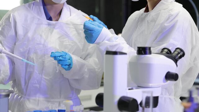 Scientists in protective gear working in a research laboratory.