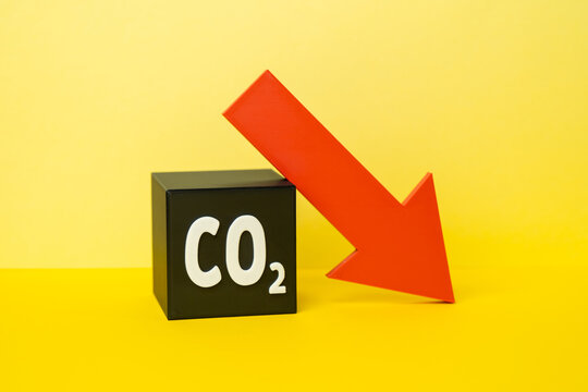 Reduction of CO2 emissions. CO2 cube and red downward arrow. Carbon reduction supports climate goals, sustainability and cleaner industrial development.
