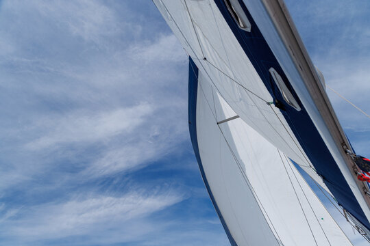 White sail against blue sky on sailing yacht