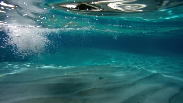 Bursting from sudden release, white bubble plume falling and widening at seabed, sunlight caustics