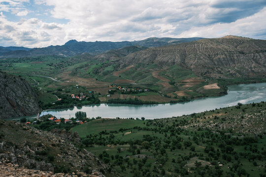 View of the Euphrates River winding through the mountainous landscape of Kemaliye with green hills and small settlements in Kemaliye, Erzincan, Turkiye.