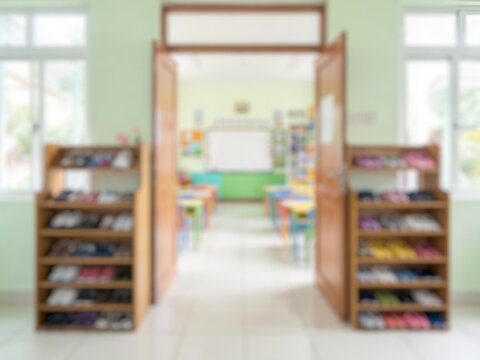 Blurred school learning space with bookshelves, classroom furniture, and an open doorway, representing education, reading, knowledge, and study.