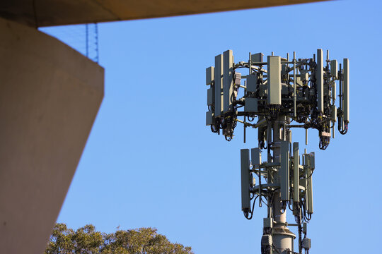 View of a 5G tower with telecommunications equipment and antennas against a clear blue sky in Sydney, New South Wales, Australia.