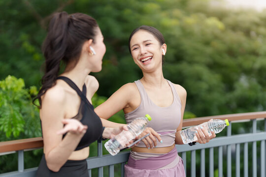 Asian women laughing and talking after outdoor workout for health and fitness