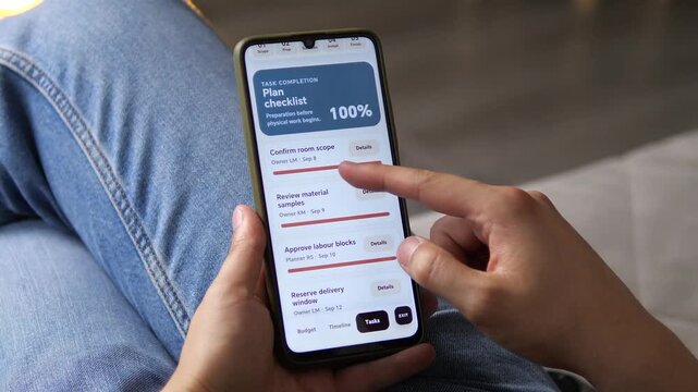 Homeowner reviews a renovation budget and completed planning tasks on a smartphone, showing digital cost control, material planning and organized preparation for a living room remodel.