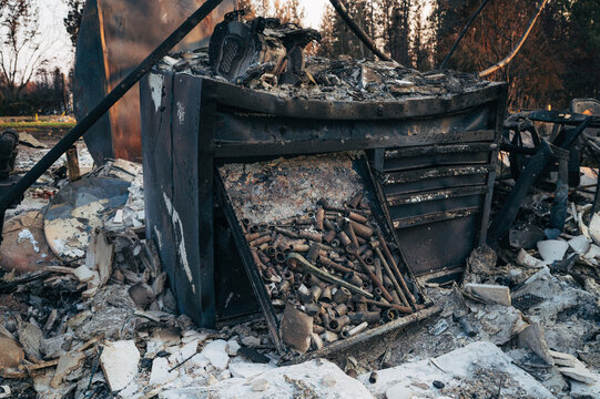 View of a charred metal tool chest filled with scattered sockets and tools amidst the debris of a wildfire in Spokane, Washington, United States.