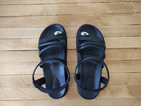Pair of black flat sandals with elastic straps and silver embellishment top view
