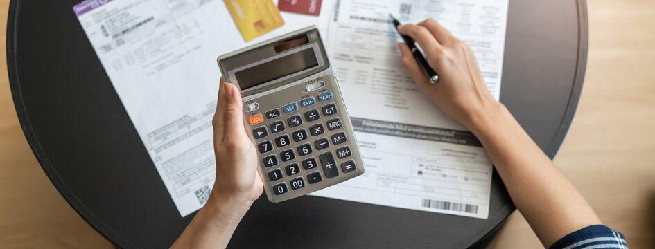 Close up hands people calculating credit card debt on the table