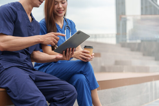 Close up of Asian healthcare workers using tablet together during breaktime