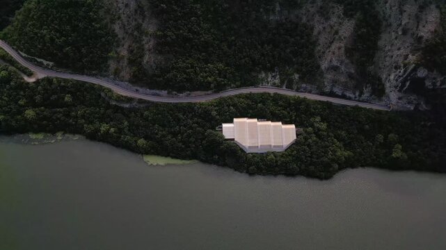 Aerial drone footage of the modern glass protective structure and visitor center at Lepenski Vir archaeological site in Iron Gate National Park, Serbia. 20.07.2026