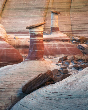 View of unique sandstone hoodoos with layered rock textures and natural stone caps in the desert landscape of Kanab, Arizona, United States.