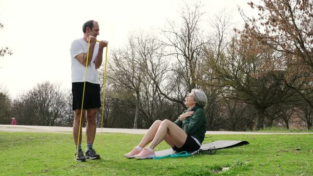 Happy mature couple doing exercises together in a public park