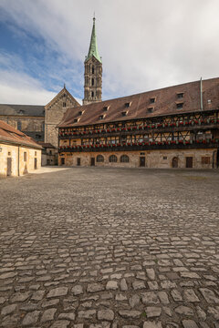 20 August 2026, The historic cobblestone courtyard of Alte Hofhaltung with the Bamberg Cathedral spire visible in Bamberg, Germany.
