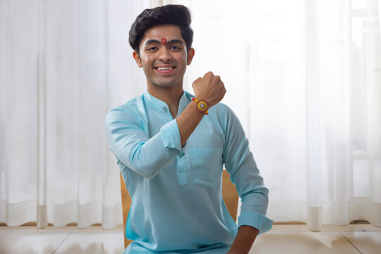 A HAPPY TEENAGER SHOWING RAKHI IN FRONT OF CAMERA