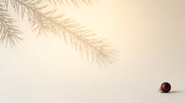 Minimalist christmas background with a dark red bauble and spruce tree branch shadow