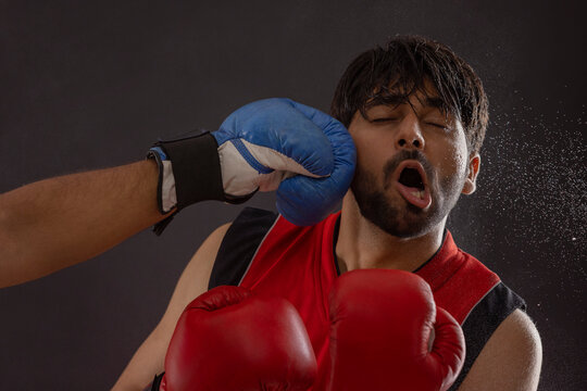 A BOXER BEING PUNCHED BY ANOTHER PLAYER DURING A BOXING MATCH