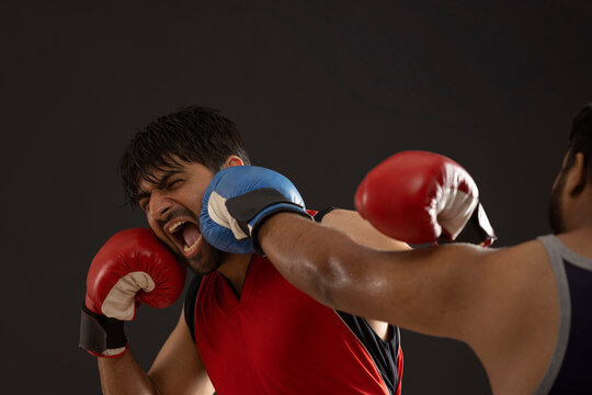 A BOXER BEING PUNCHED BY ANOTHER PLAYER WHILE IN A MATCH