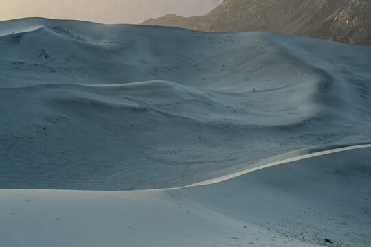 View of Sarfaranga Cold Desert Shigar with rolling sand dunes and soft shadows under a clear sky in Skardu, Gilgit, Pakistan.