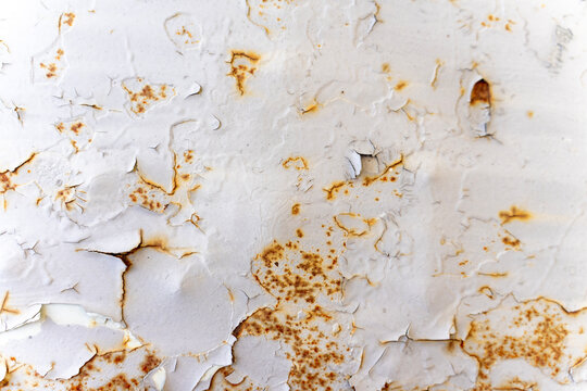 Cracked white painted metal surface with rust spots, peeling paint texture, and green drops, representing material wear, corrosion, and weathering.