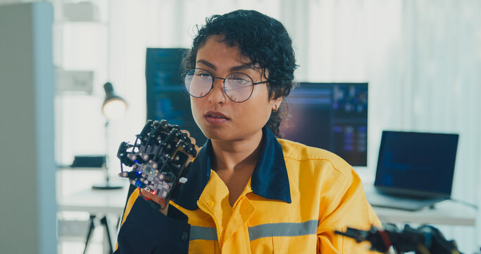 Close-up young Black female engineer coding AI robot arm in modern laboratory. Robotics, artificial intelligence, technology, stem, future, innovation, diversity, automation, machine learning concept.