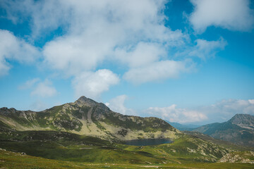 Fototapeta premium Rocky mountain ridge beneath dramatic clouds and blue summer sky