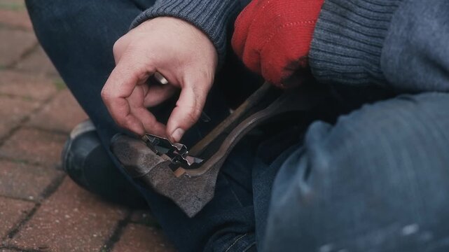 Installing brake pad retaining clips onto caliper bracket during assembly. Brake hardware preparation ensuring proper pad alignment and smooth movement. DIY automotive repair assembling caliper