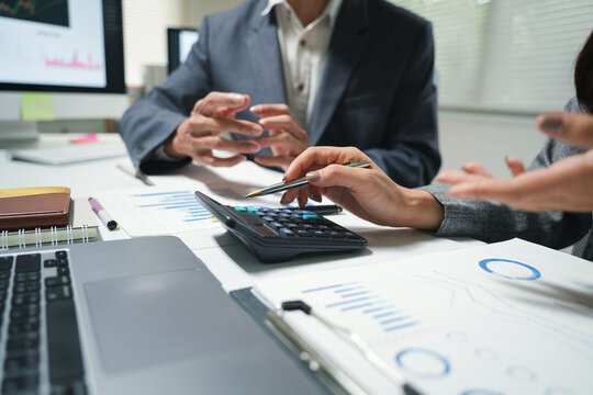 Business Team Reviewing Financial Charts With Calculator
