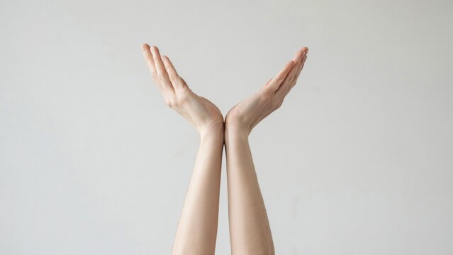 Two human hands reaching upward against a plain light gray background