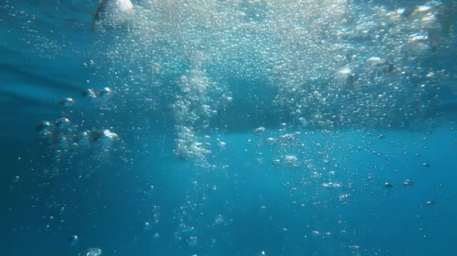 Underwater bubbles rising through turquoise water during daylight