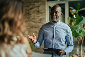 Obraz premium Black businessman discussing work with female colleague in office