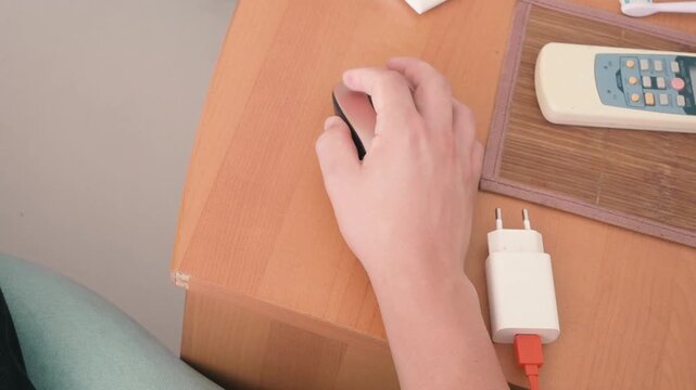 High Angle View of Hand Using Wireless Computer Mouse on Wooden Desk