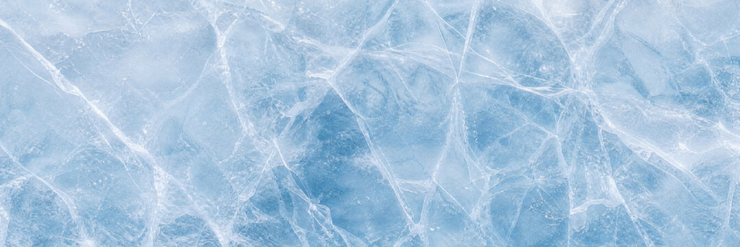 Blue ice texture with white cracks and fissures on frozen water surface