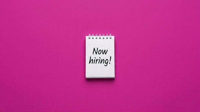 Now hiring text written on notepad against pink background