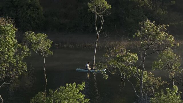 Aerial drone view of visitors kayaking and making coffee at sunrise on Suoi Tia, Tuyen Lam Lake in Xuan Huong, Da Lat, Vietnam, enjoying a peaceful morning in nature.