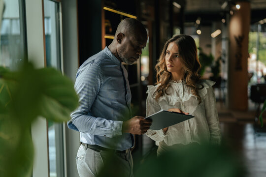 Diverse business professionals discussing documents in modern office