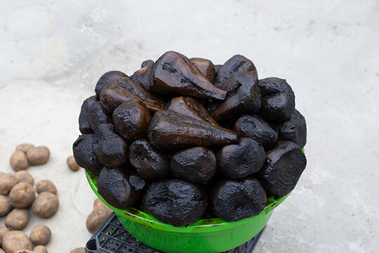 Boiled sugar beet piled in a green basin at an oriental bazaar in Bukhara, Uzbekistan. Traditional market display with organic produce on concrete ground, ideal for travel and food culture content.